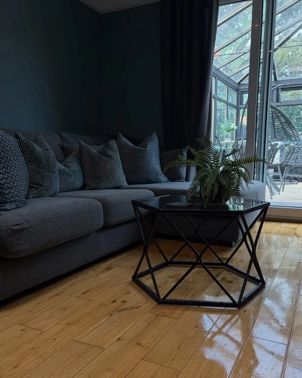 A living room with a polished oak floor and plumped cushions after a visit